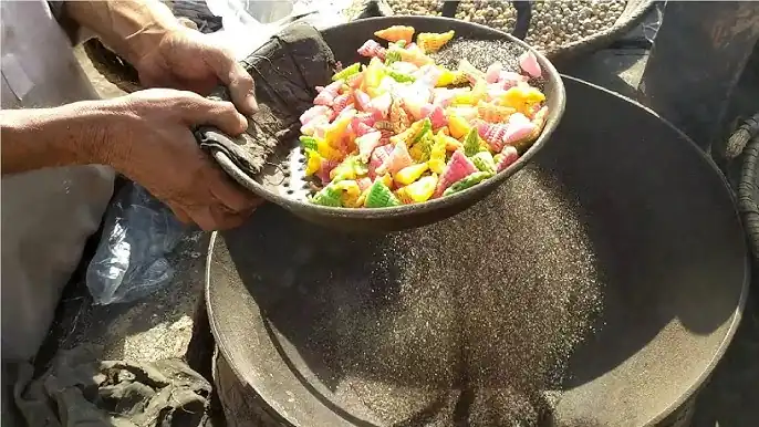 Fotografía de una persona cocinando con arena caliente
